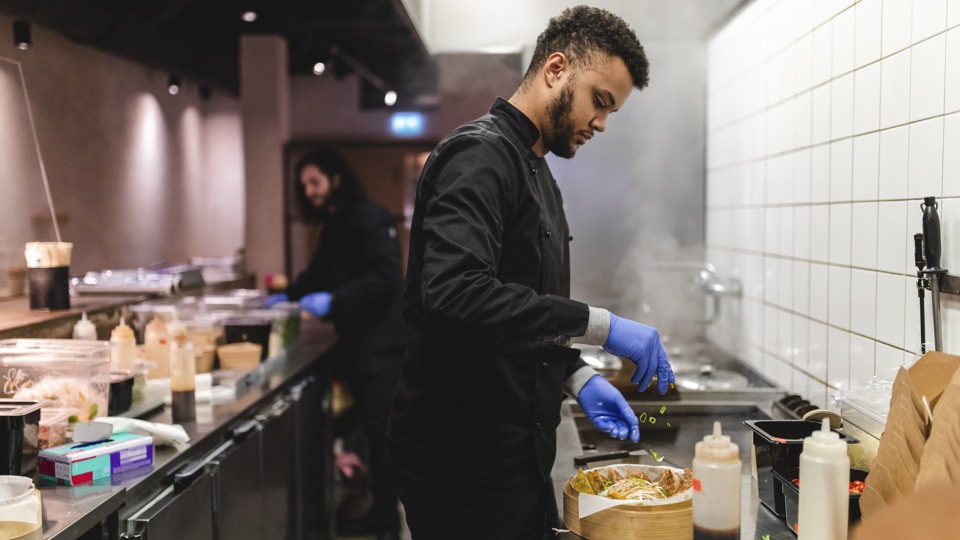 En man förbereder mat i ett restaurangkök