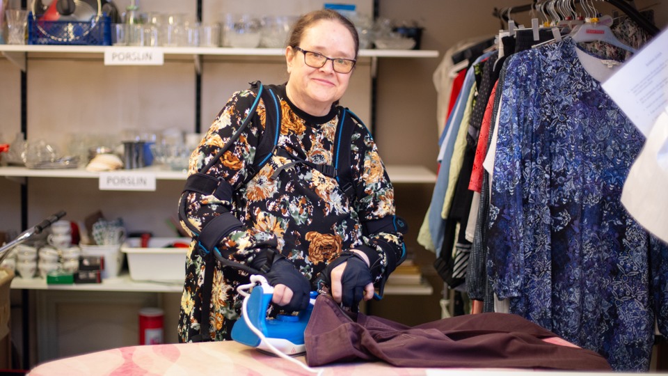 Med hjälp av arbetshjälpmedel, bland annat eldrivna robothandskar kan Margareta Maj-Brittsdotter arbeta på Hela Människans second hand-butik i Kristinehamn.