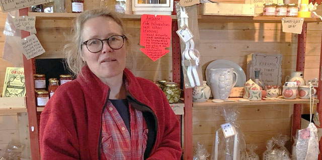 Kvinna med blont hår och glasögon vid butikskassa