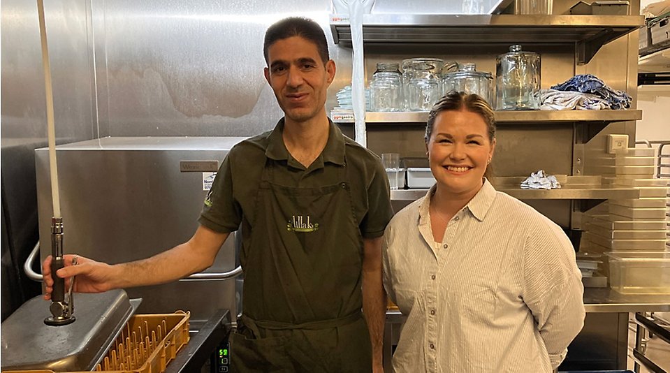 Diskaren Ahmed står bredvid kaféägaren Sara i diskrummet.